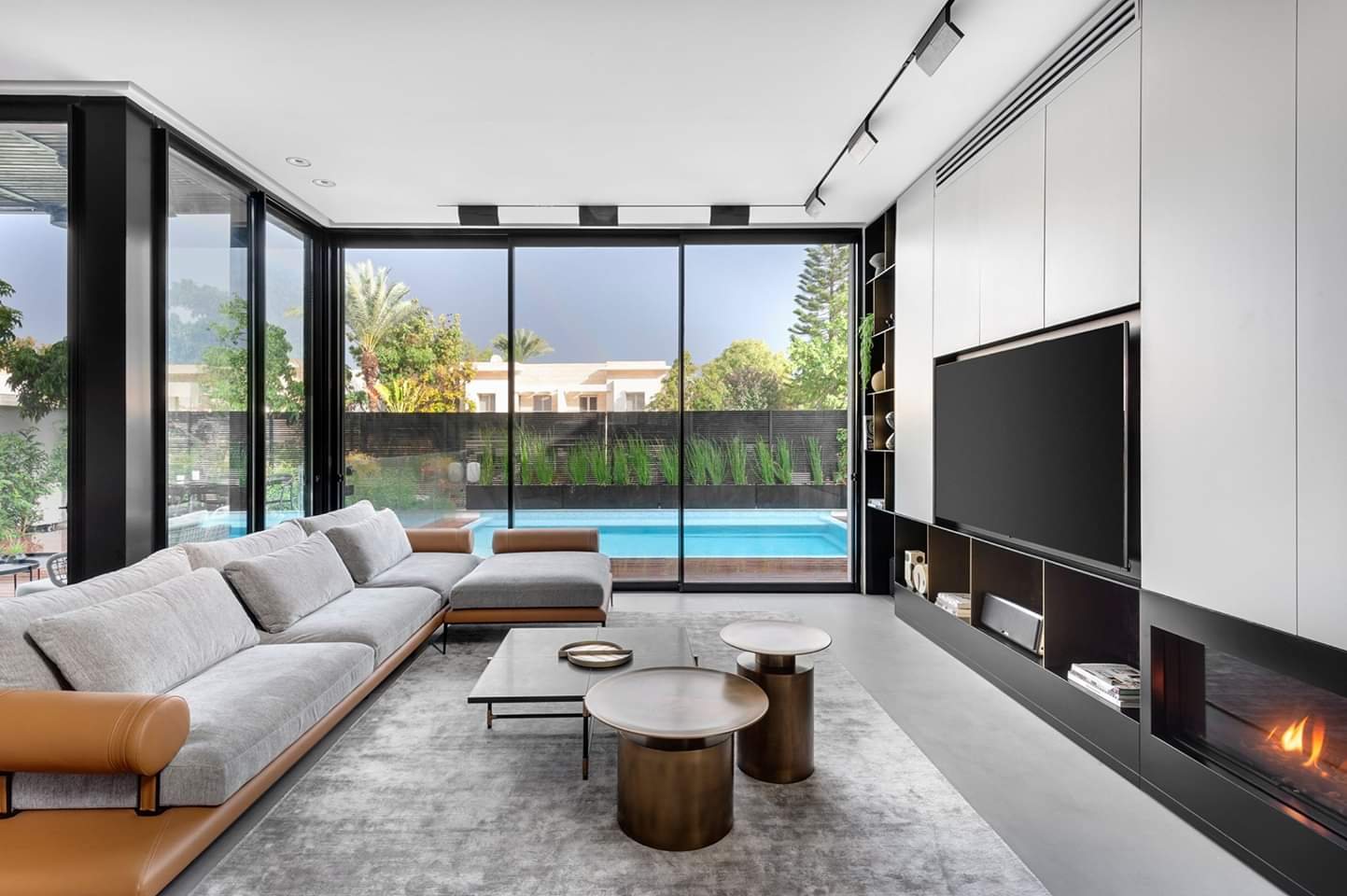 Long low unit running past the fire into the window wall — custom media wall by iKitchen Cabinetry